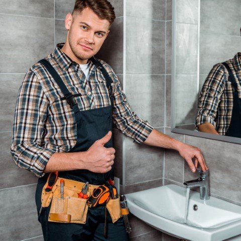 handsome-installer-standing-near-faucet-with-flowi-2024-11-14-02-04-23-utc